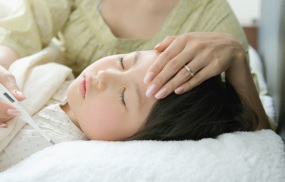 A child resting in bed with a thermometer, showing how parents should focus on overall symptoms and hydration rather than just the fever reading.