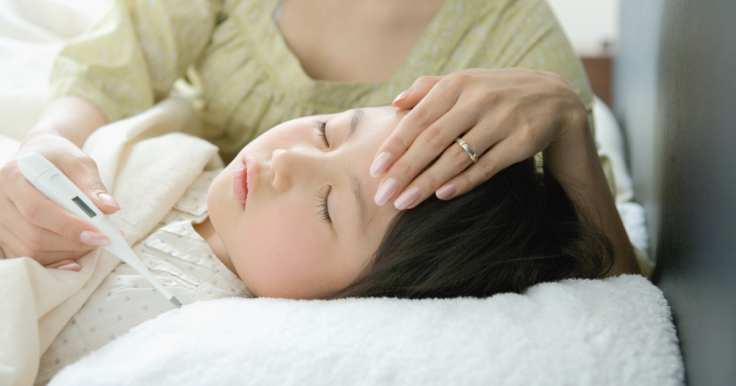 Child lying in bed having a fever