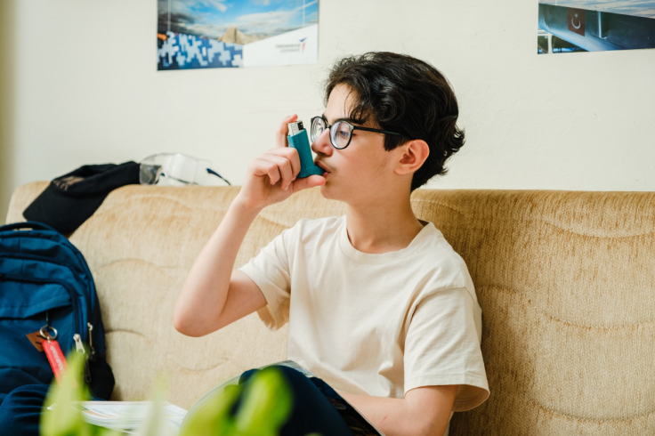 Child using an inhaler to manage asthma attack