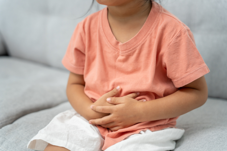 Child clutching tummy because of stomach ache