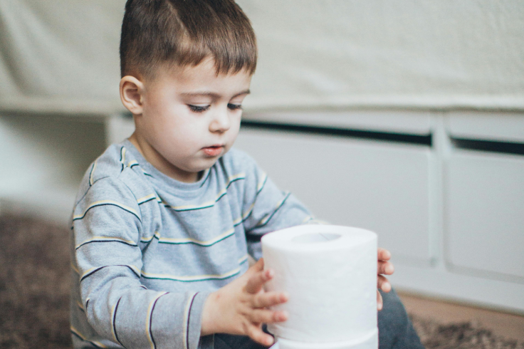 Child holding a toilet paper for poo break