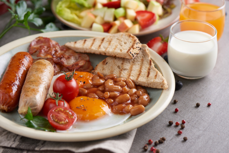 breakfast with fried eggs, sausage, tomato, beans, and toast