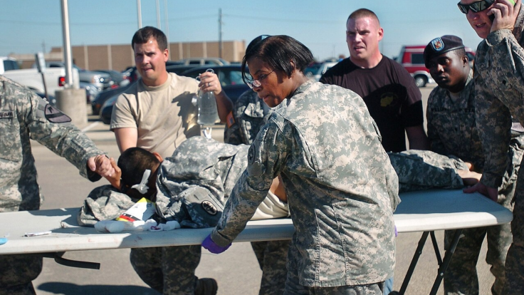 First responders and soldiers transport a fellow soldier wounded