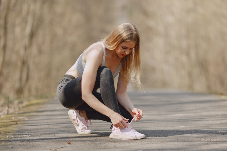 A young athletic woman ties her shoelaces